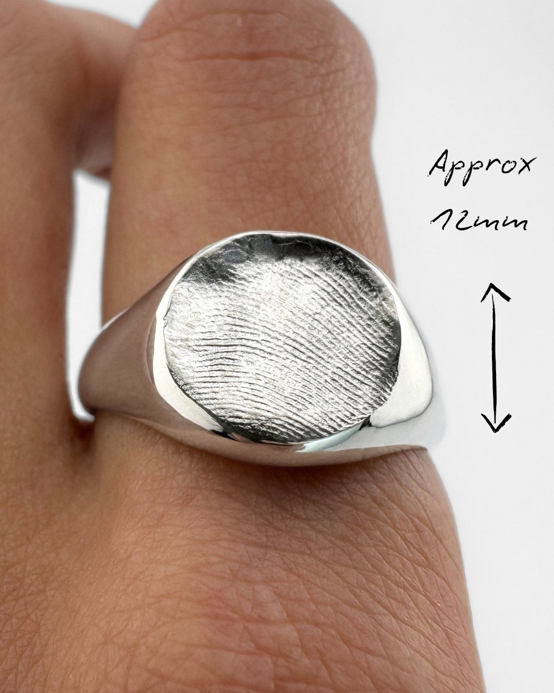 Close up of a hand wearing a silver fingerprint ring
