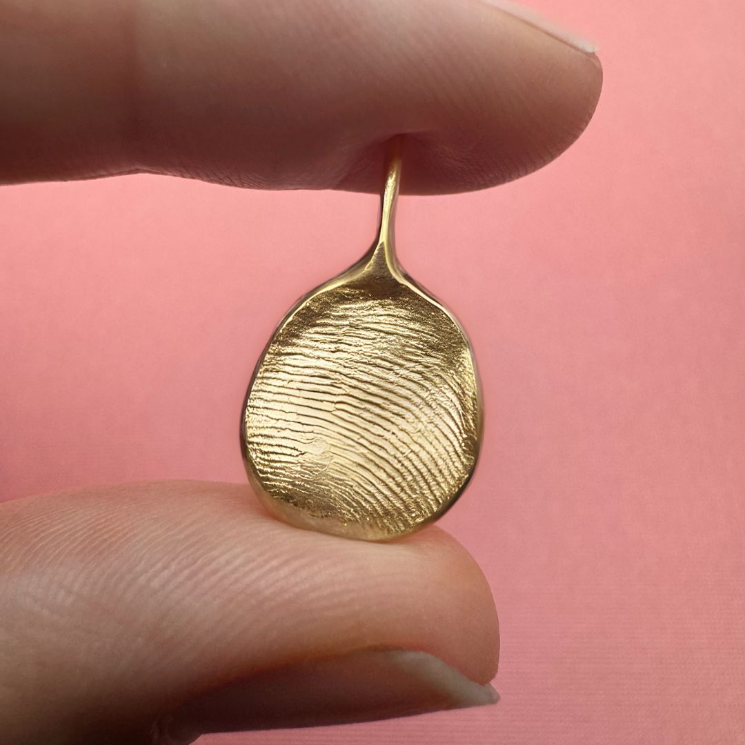 Person holding 9ct gold fingerprint pendant