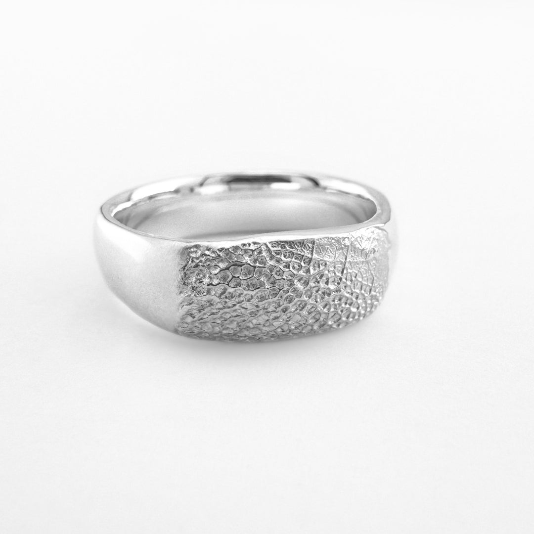 Silver paw print ring band on light grey background