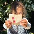 Child holding up wax impression prints