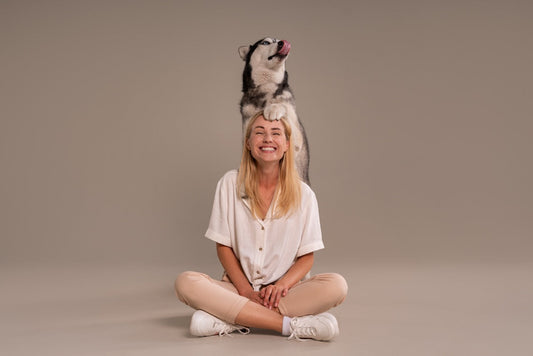 Lady sat on the floor with husky dog leaning on her head