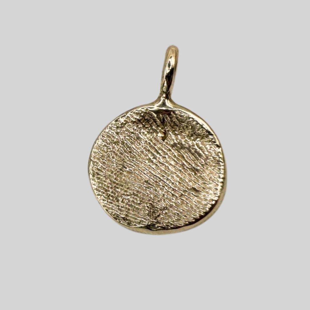 9ct gold fingerprint impression pendant on grey background