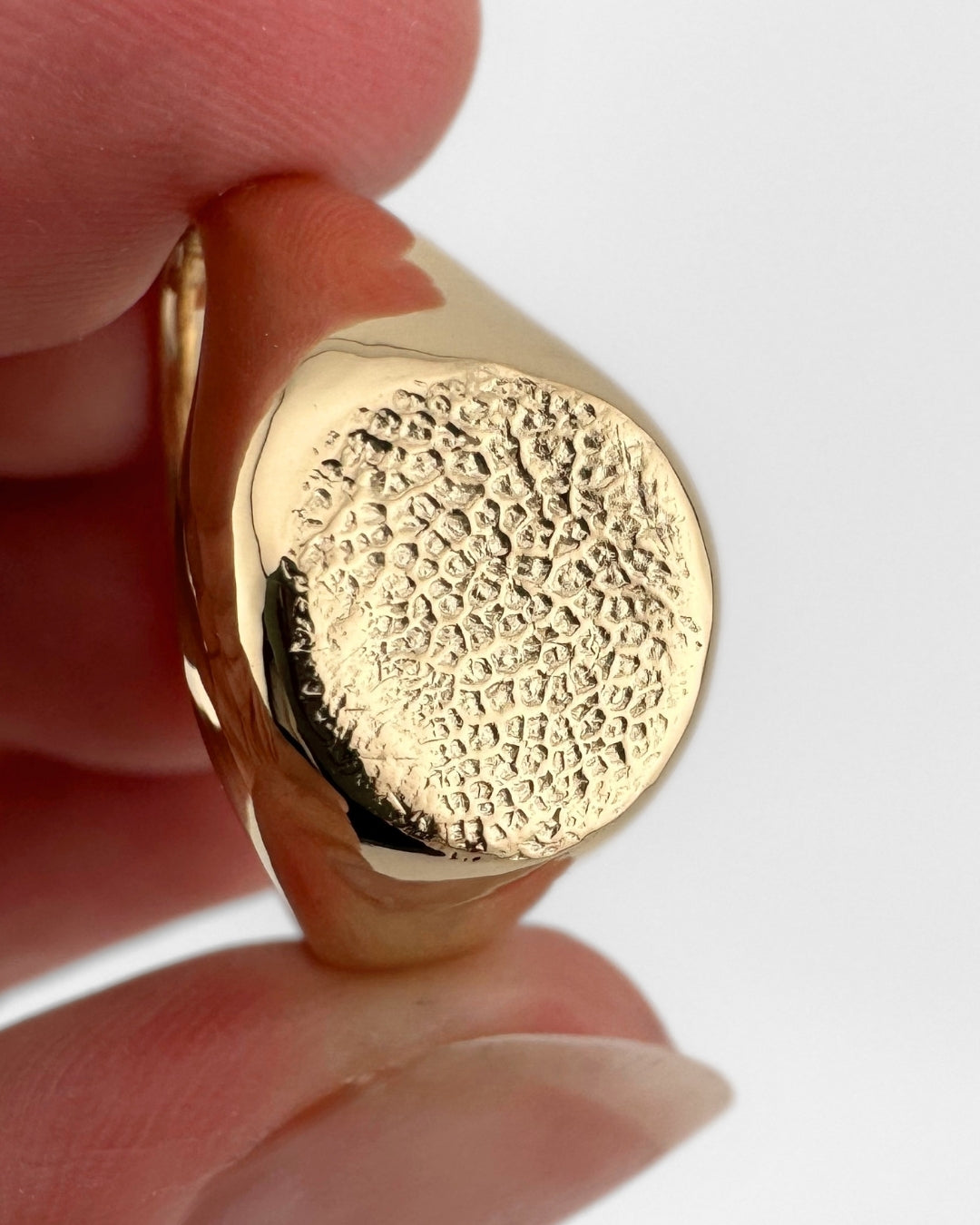 Close up of gold signet ring with dog's nose print impression
