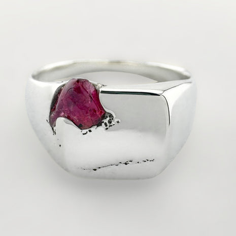 Silver signet ring with a pink sapphire on a white background