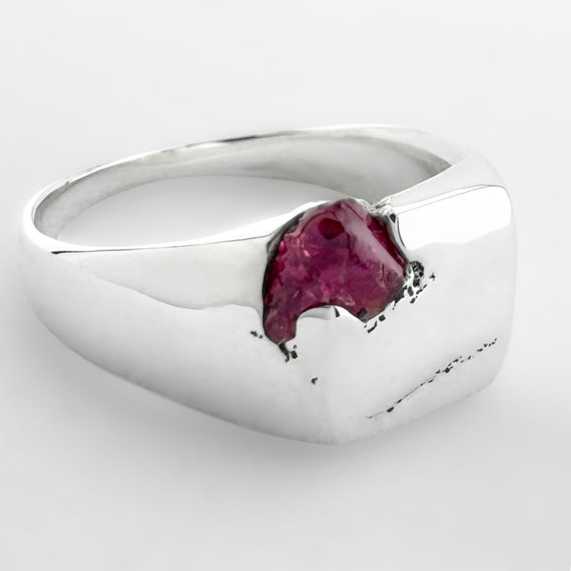 Silver signet ring with a pink sapphire on a white background