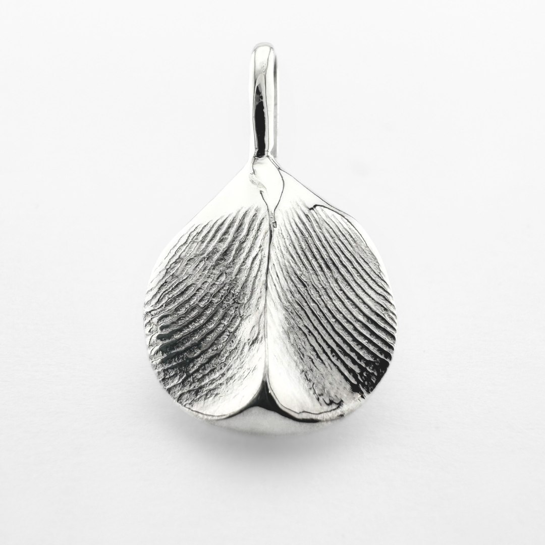 Double sided silver fingerprint pendant on light grey background