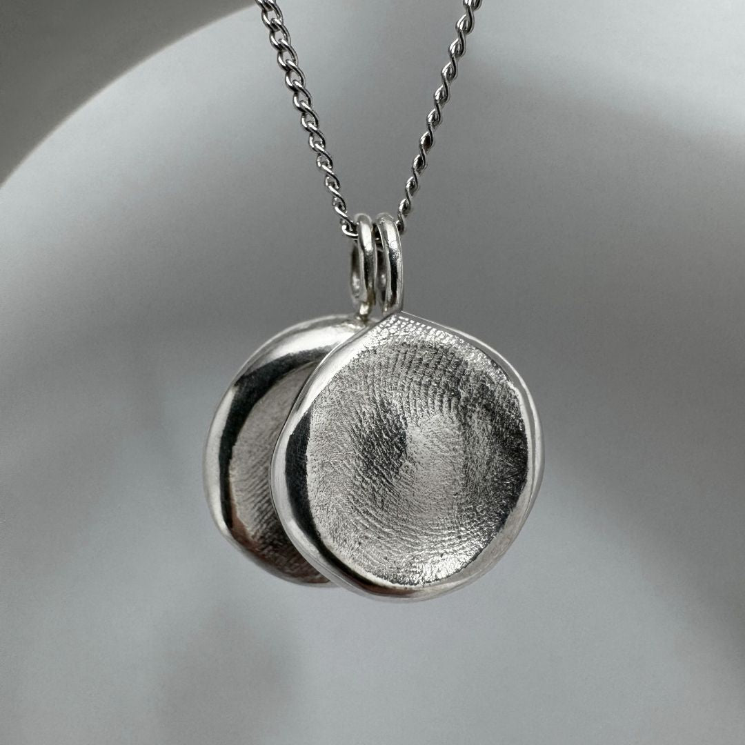 Two sterling silver fingerprint impression pendants on chain