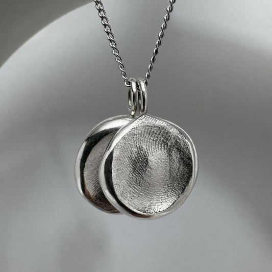 Two sterling silver fingerprint impression pendants on chain