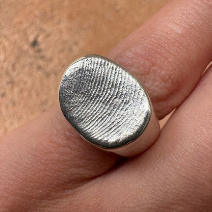 Person wearing a sterling silver fingerprint impression signet ring