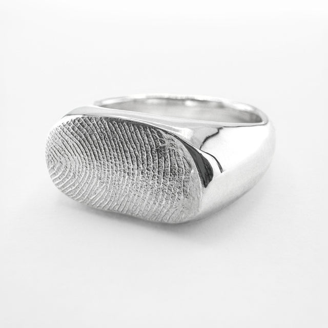 Silver fingerprint signet ring on light grey background