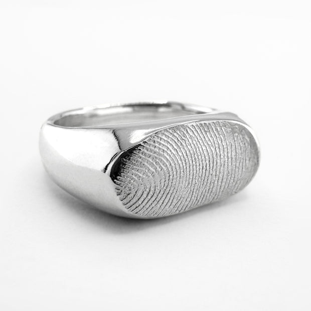 Silver fingerprint signet ring on light grey background