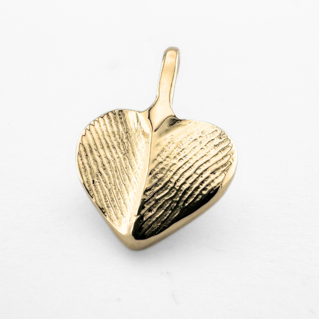 Gold fingerprint pendant on light grey background