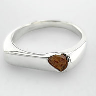 Thin silver signet ring with a honey coloured sapphire on a light grey background