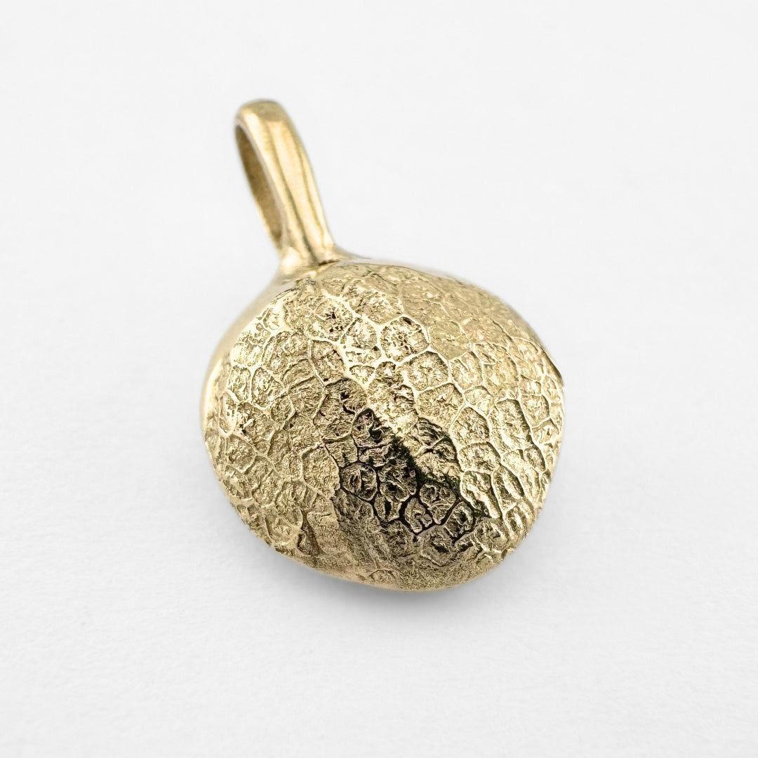 Gold dog's nose print pendant on light grey background