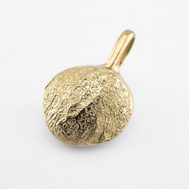 Gold dog's nose print pendant on light grey background