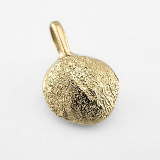 Gold dog's nose print pendant on light grey background
