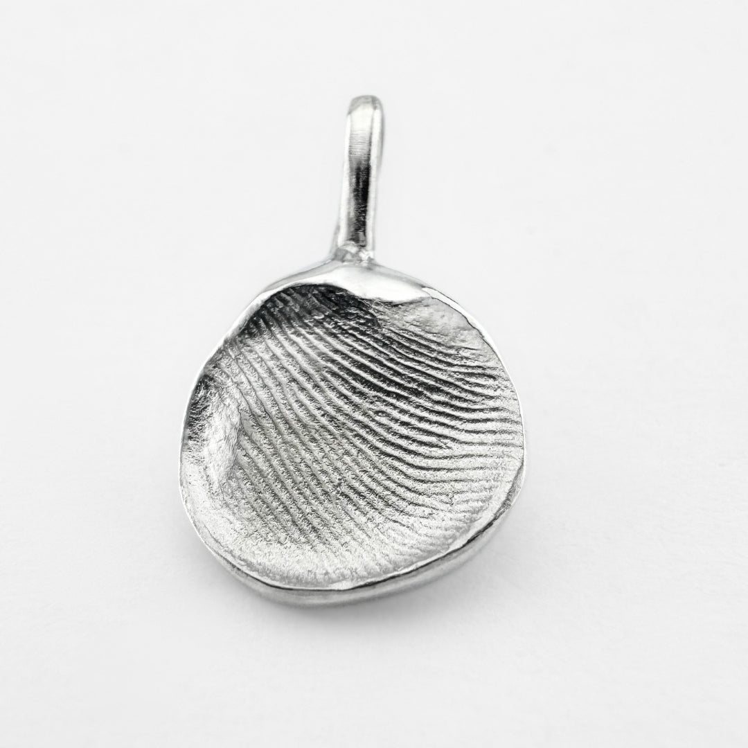 Silver fingerprint pendant on light grey background