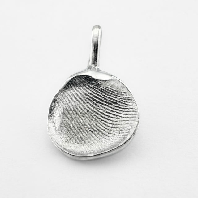 Silver fingerprint pendant on light grey background