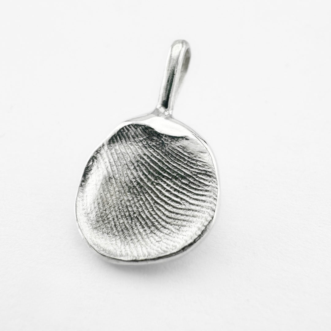 Silver fingerprint pendant on light grey background