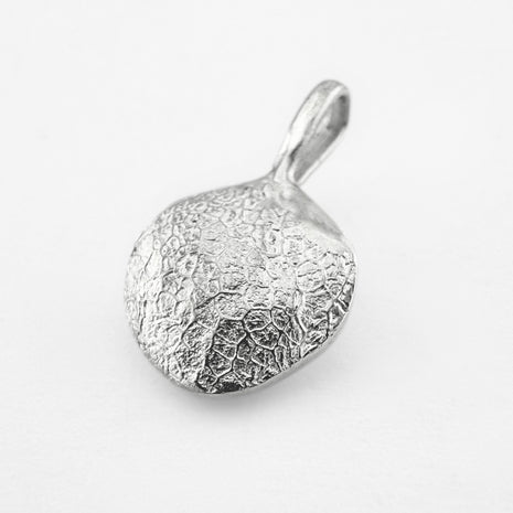 Silver dog's nose print pendant on light grey background