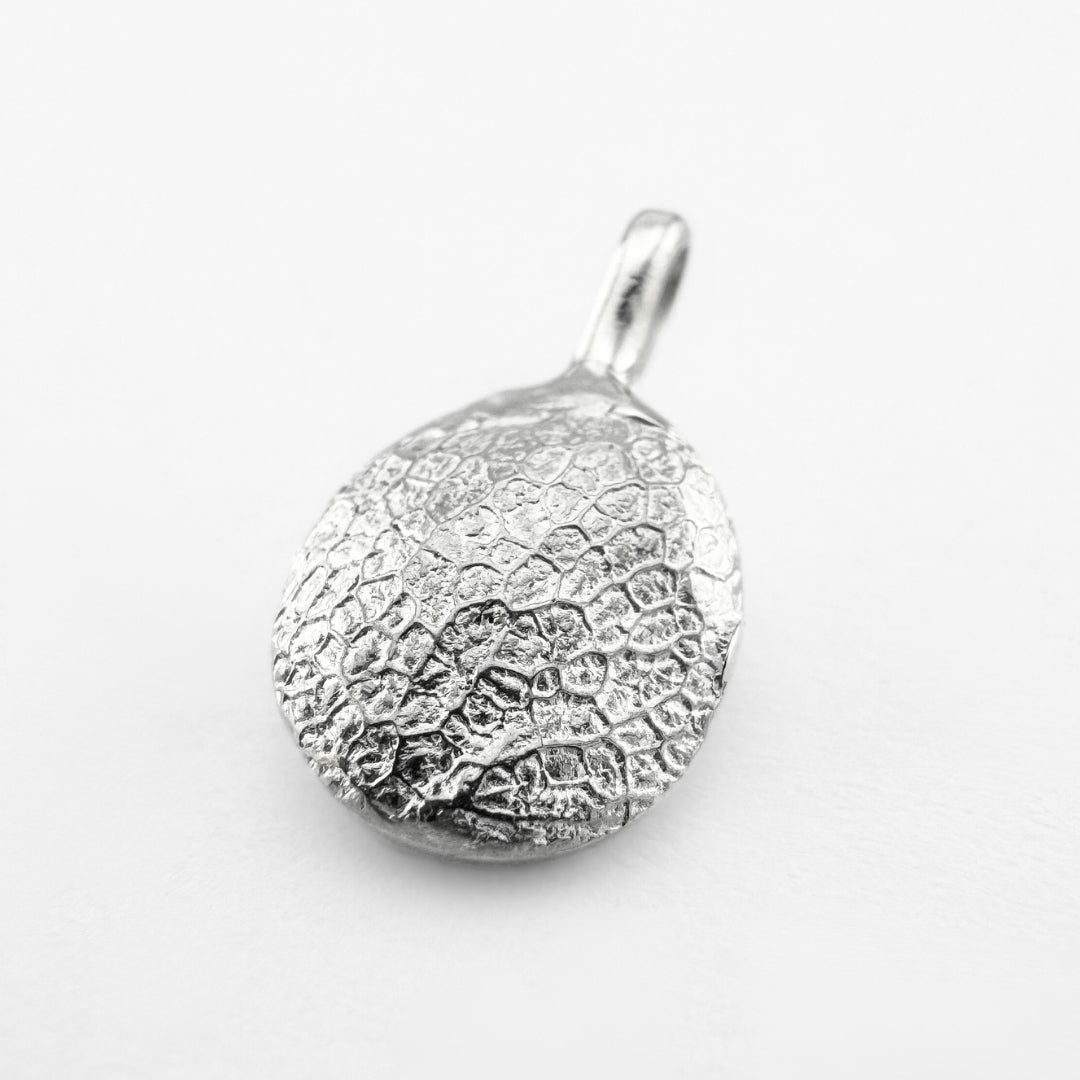 Silver dog's nose print pendant on light grey background