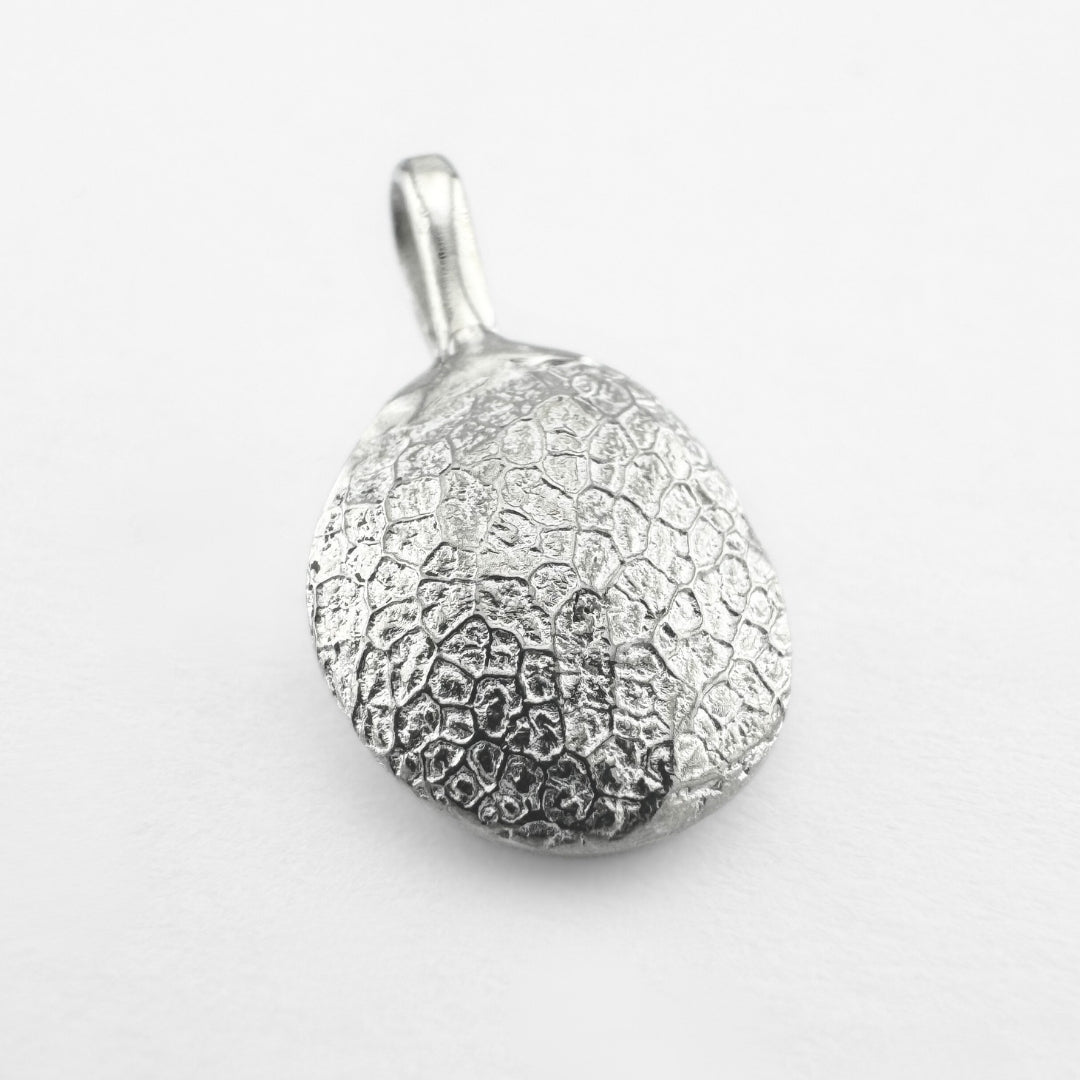 Silver dog's nose print pendant on light grey background