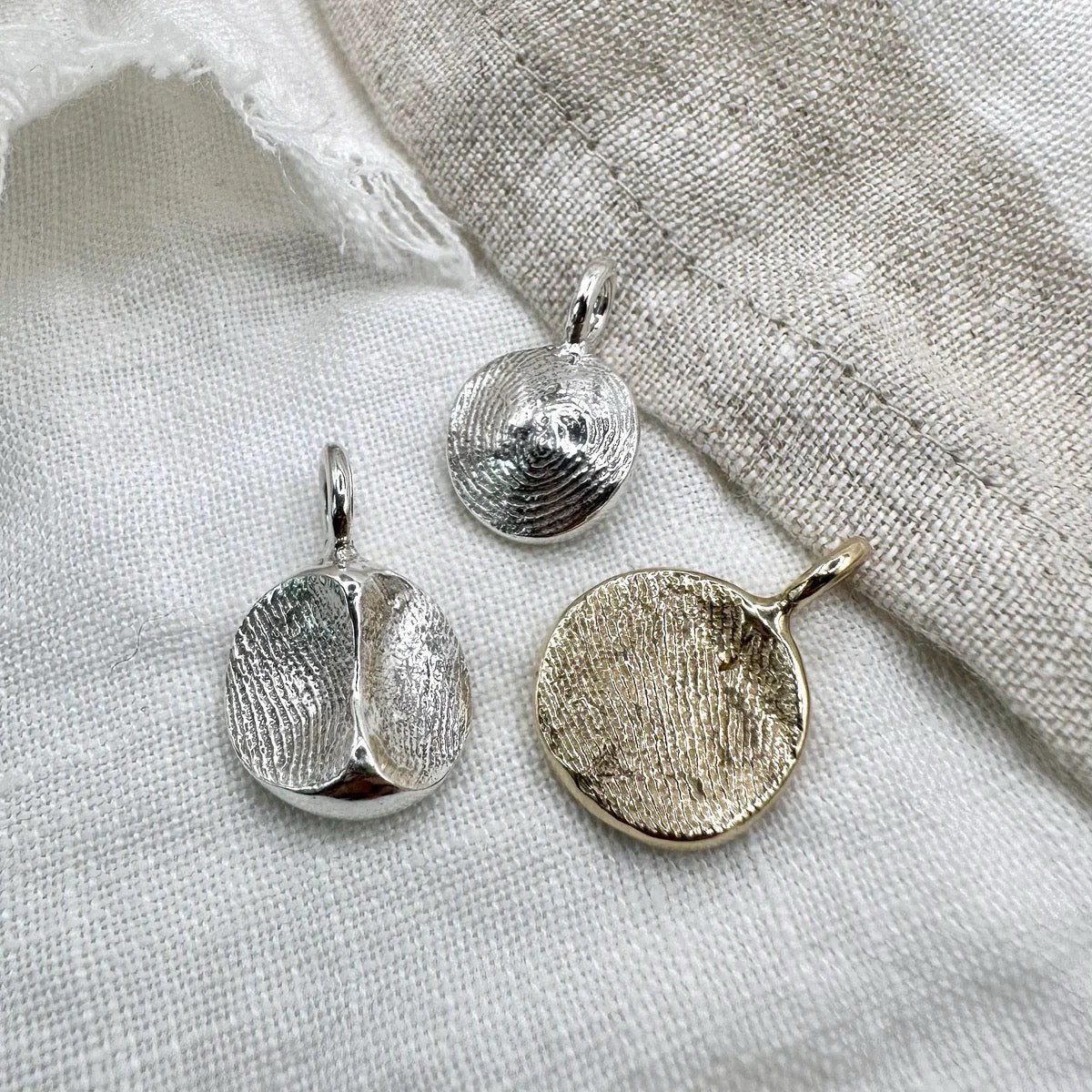 Three custom handmade pendants with fingerprint imprints