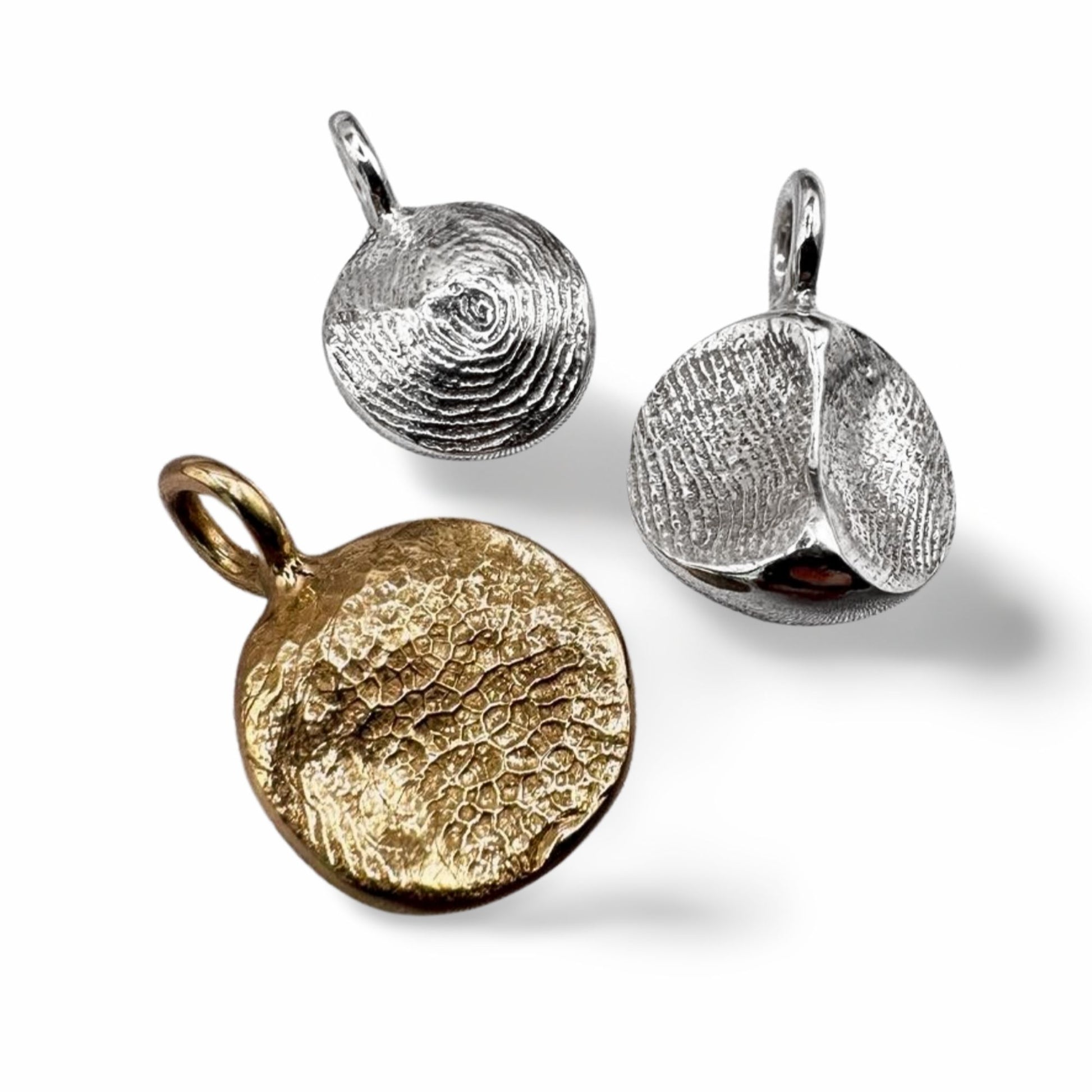 Fingerprint pendants in sterling silver and gold on transparent background