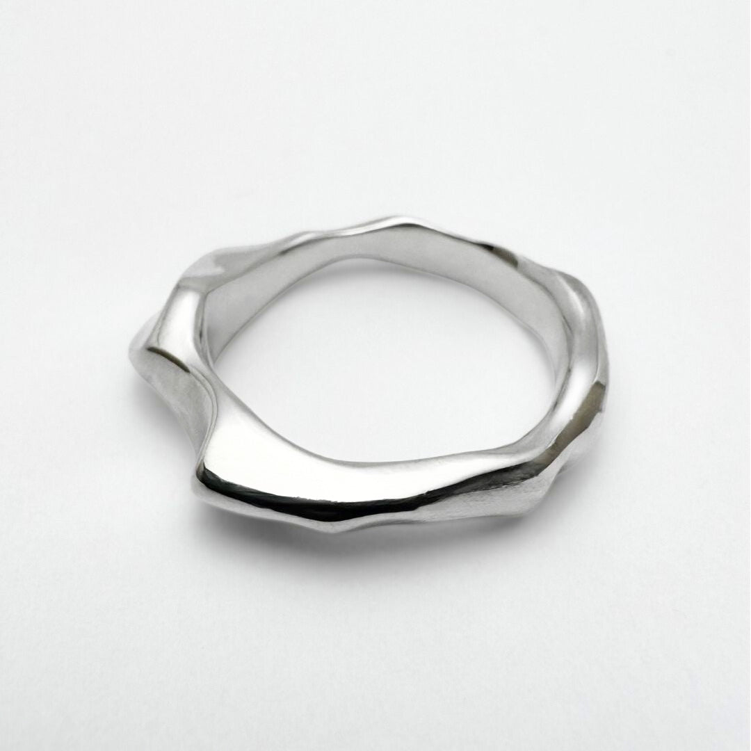 Silver ring with a geometric design on a white background