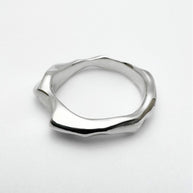 Silver ring with a geometric design on a white background