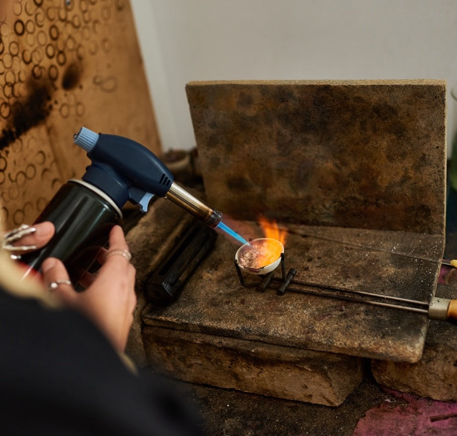 Melting sterling silver granules in a crucible to cast a piece of jewellery