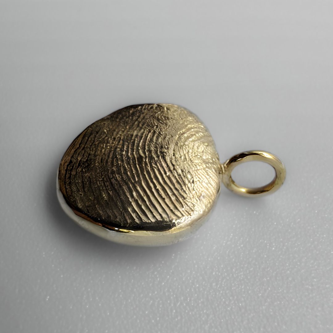 Gold fingerprint pendant on white background