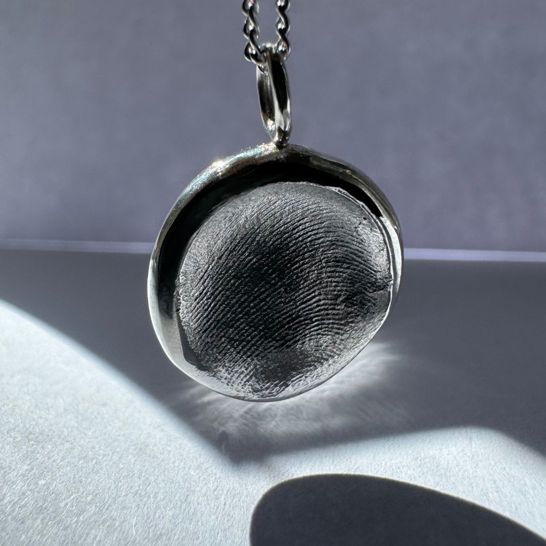 Sterling silver fingerprint pendant hanging on silver chain