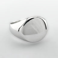 Silver signet ring on a light grey background