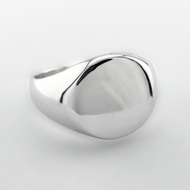 Silver signet ring on a light grey background