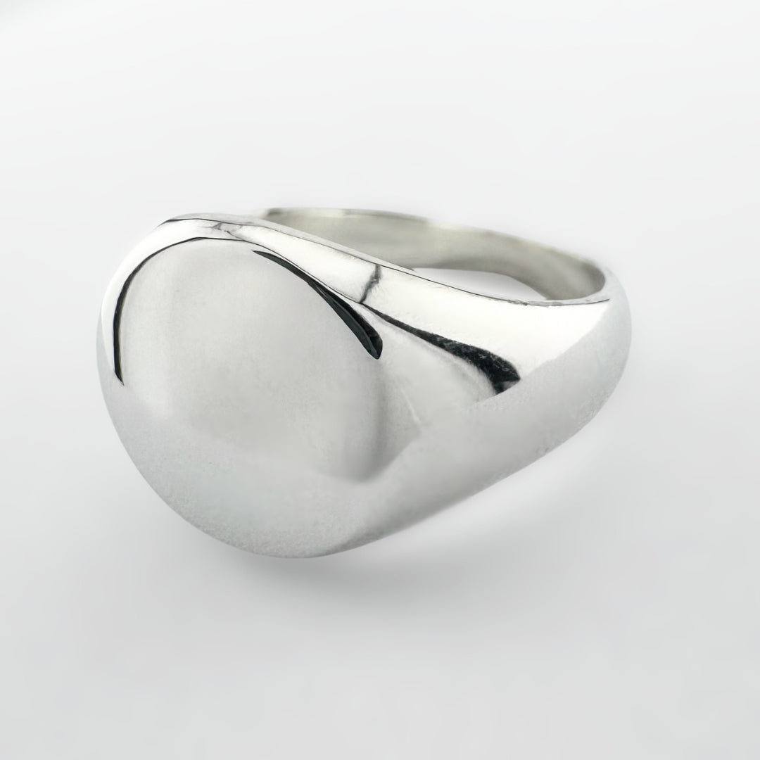 Silver signet ring on a light grey background