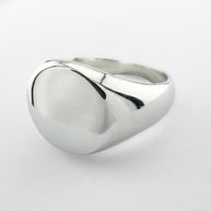 Silver signet ring on a light grey background