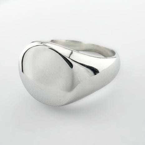 Silver signet ring on a light grey background