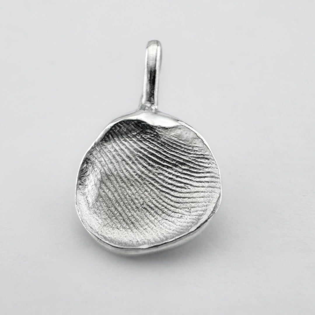 Sterling silver fingerprint pendant on light grey background
