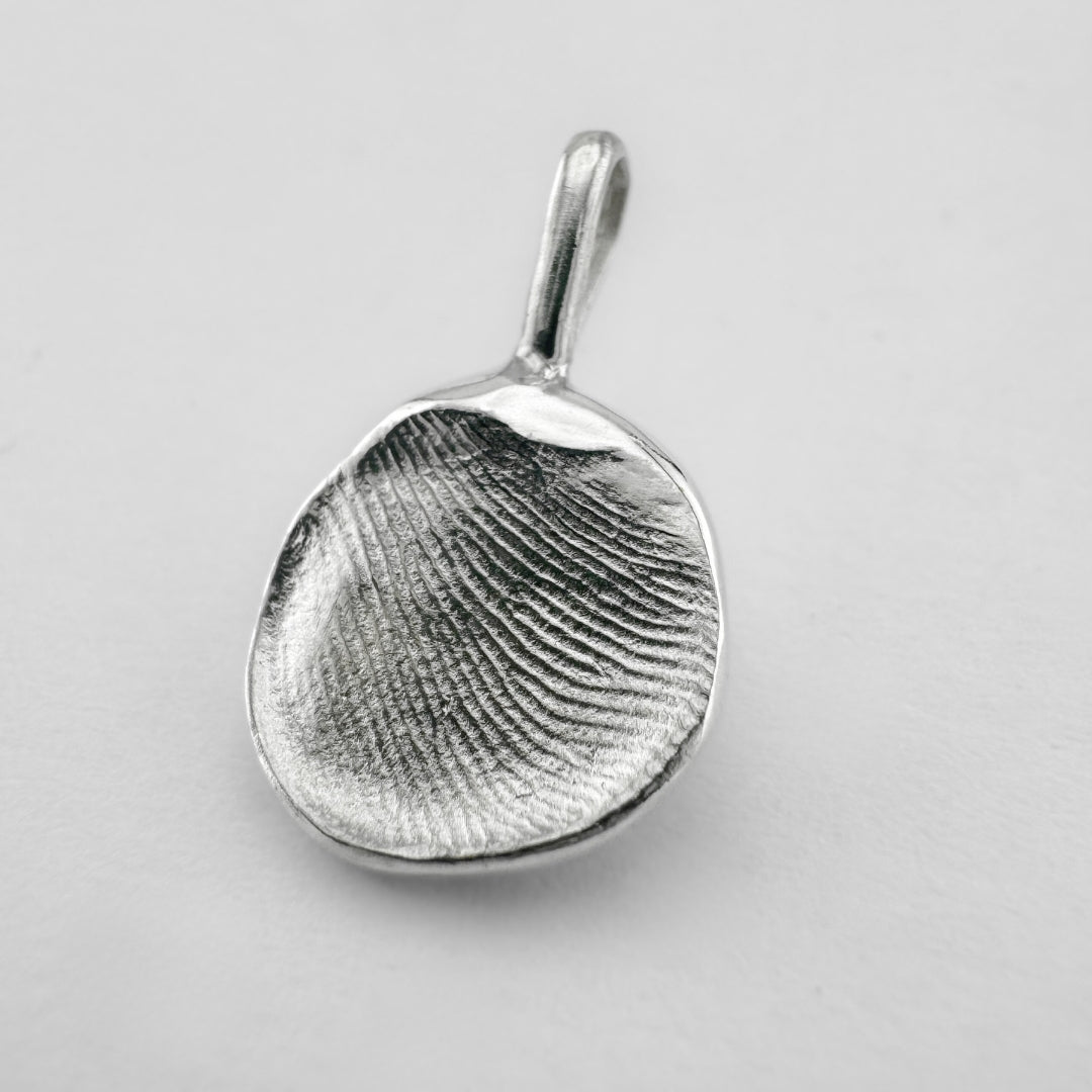 Sterling silver fingerprint pendant on light grey background