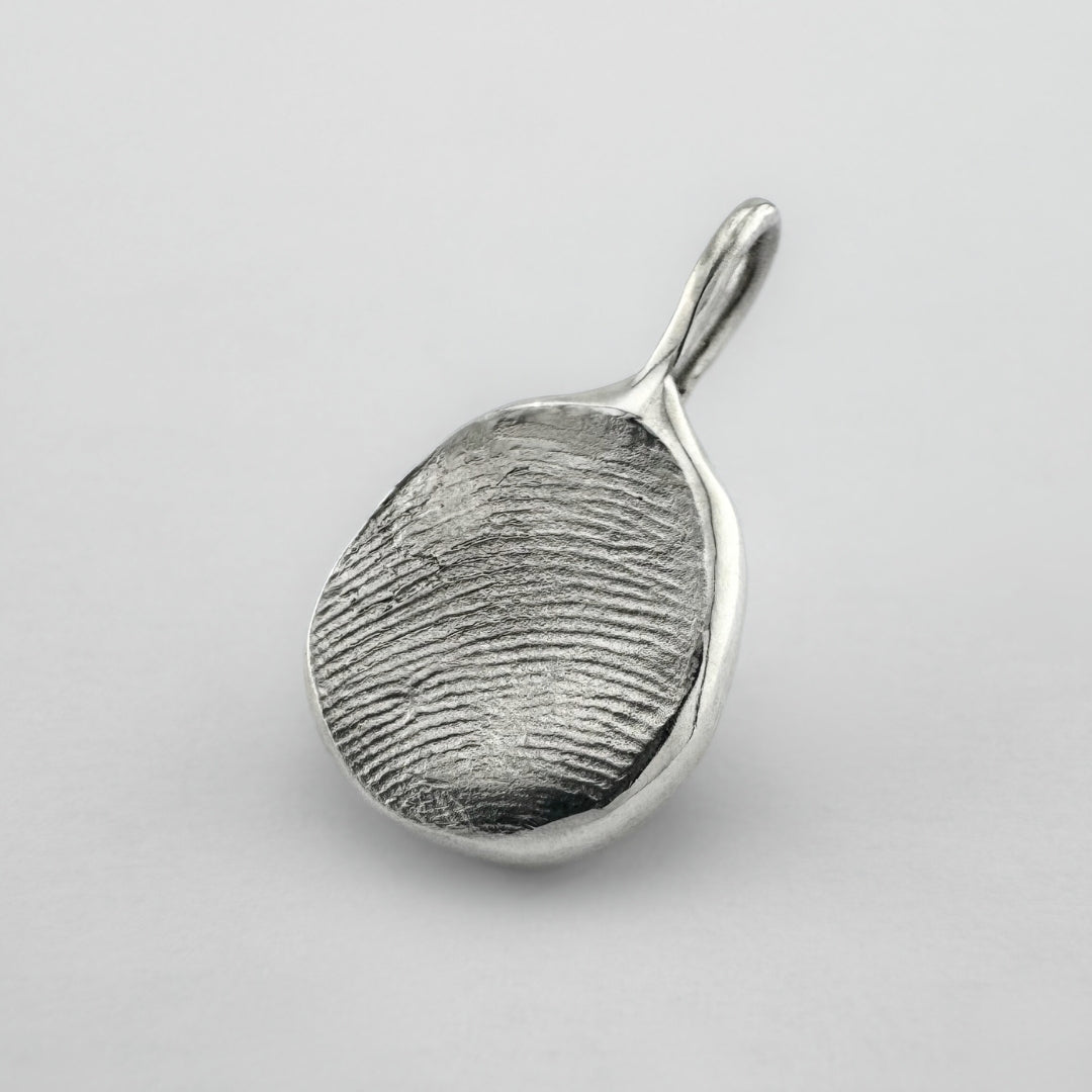 Sterling silver fingerprint pendant on light grey background