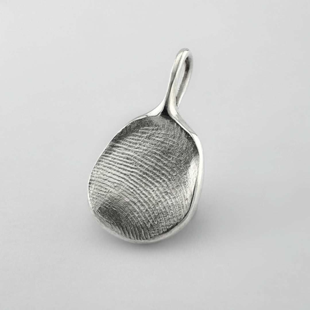 Sterling silver fingerprint pendant on light grey background