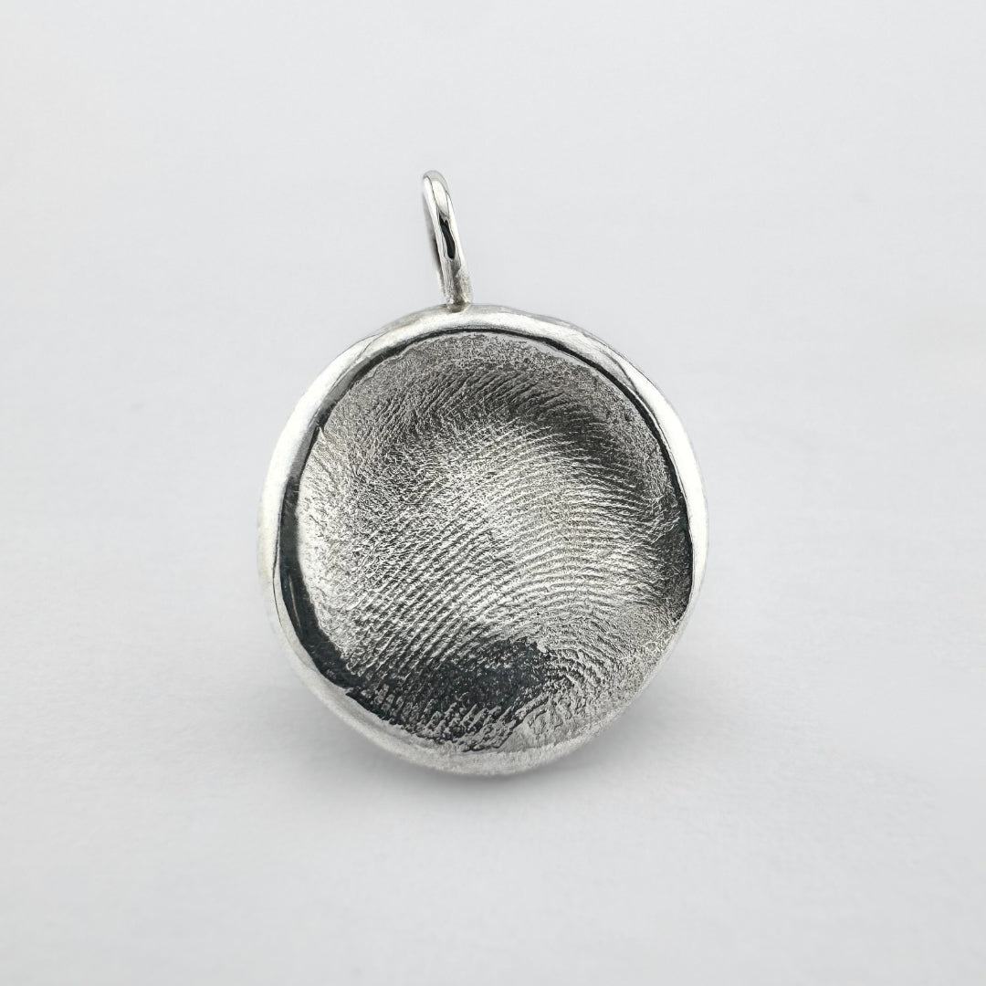 Sterling silver dogs nose print pendant on light grey background