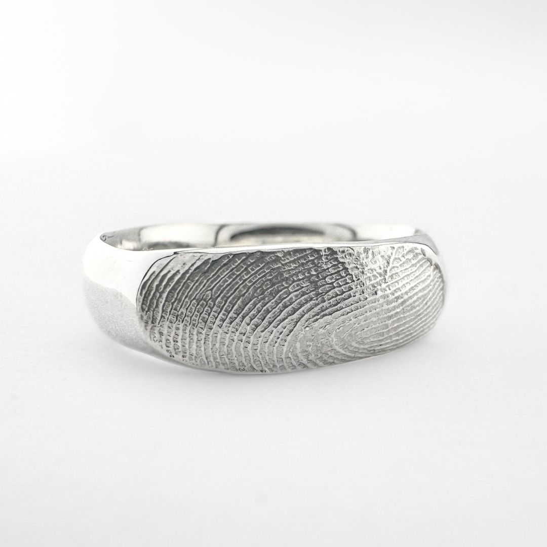 Silver fingerprint ring band on light grey background