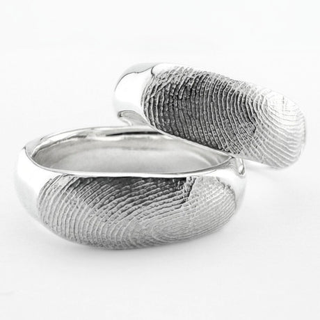 Two sterling silver fingerprint ring bands on light grey background