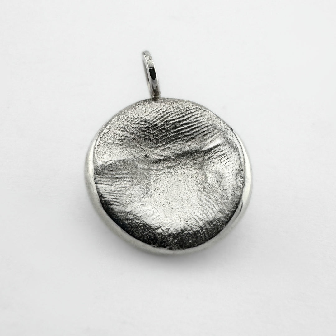 Sterling silver fingerprint pendant on light grey background
