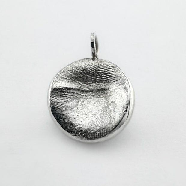 Sterling silver fingerprint pendant on light grey background
