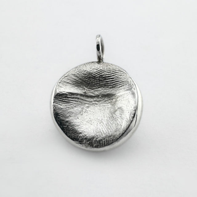 Sterling silver fingerprint pendant on light grey background