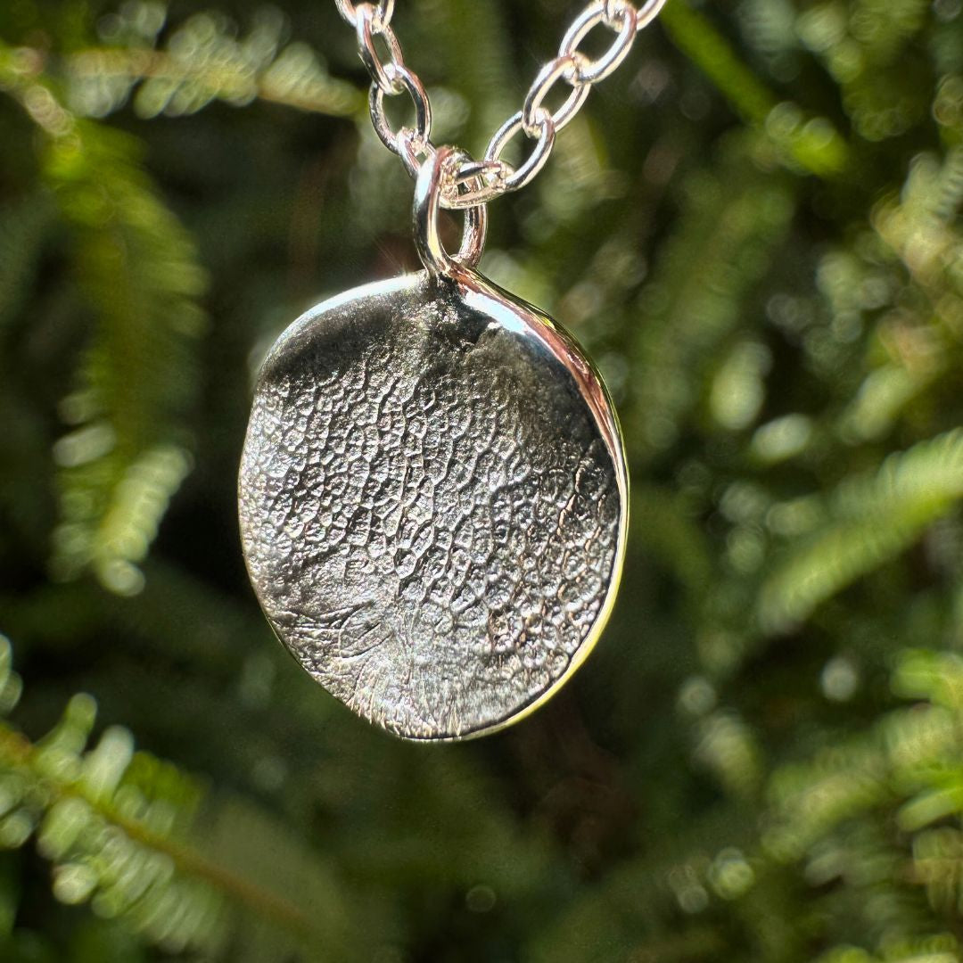 Close up of silver dogs nose print pendant