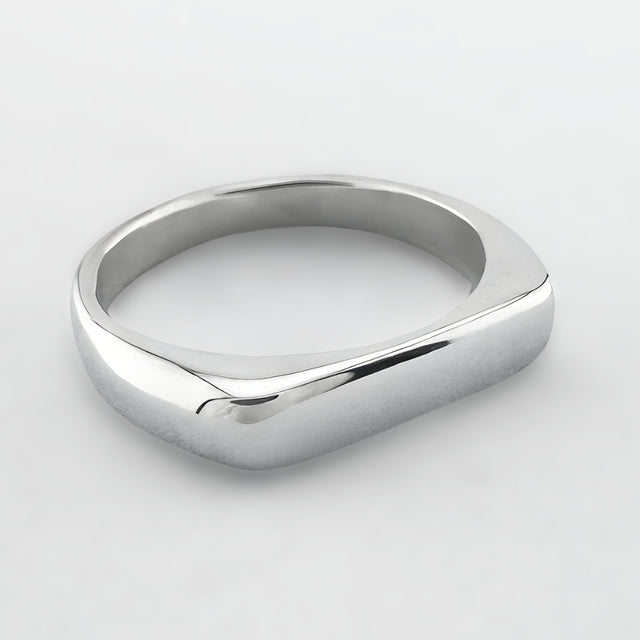 Thin silver signet ring on a light grey background